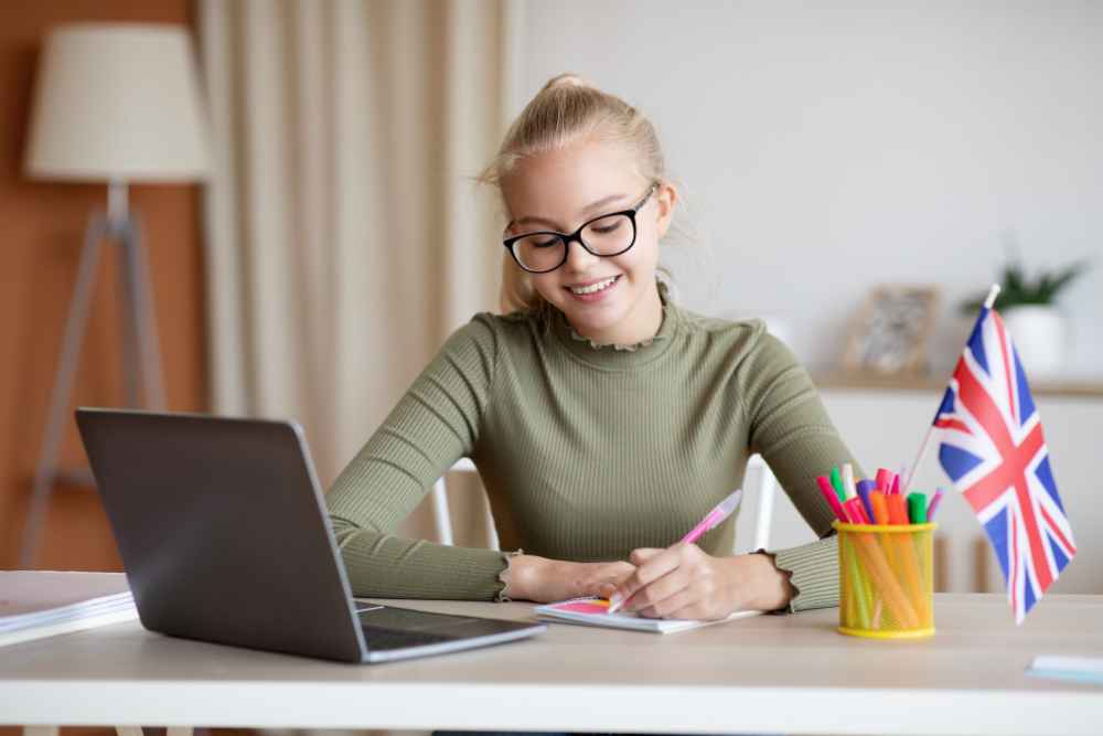 mulher com notebook e caderno aprendendo expressões em inglês