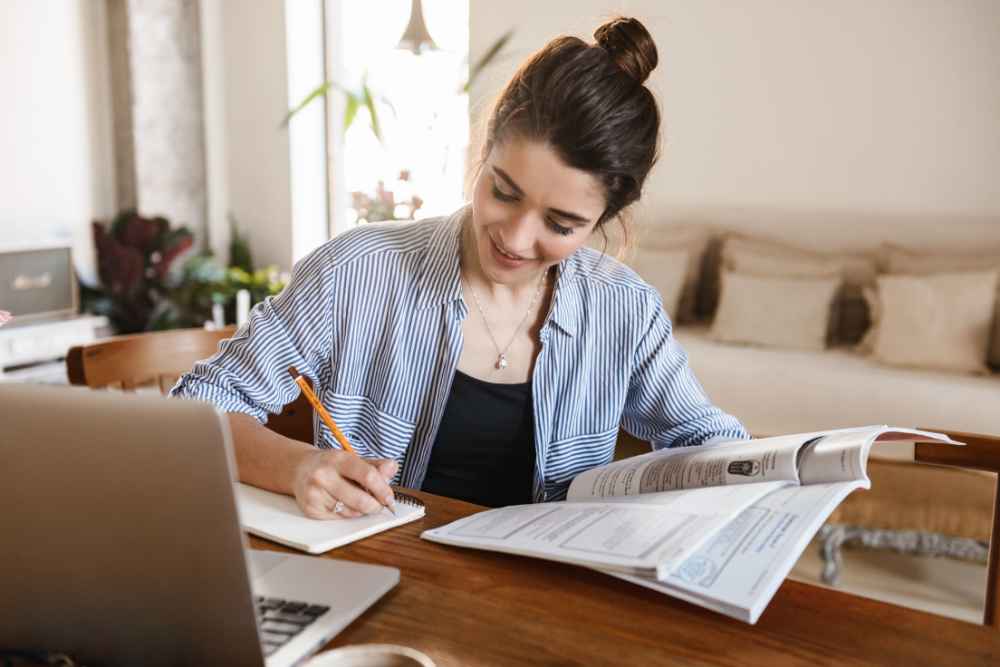 mulher estudando com livros após saber aprender inglês em casa